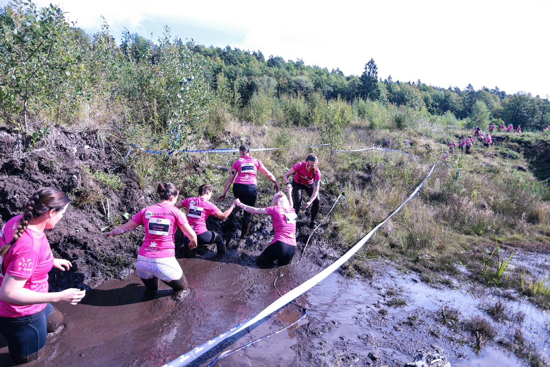 Et av flere gjørmete hinder jentene måtte gjennom under løpet på Lauvåsen. Her var det lagånd, latter og samarbeid.