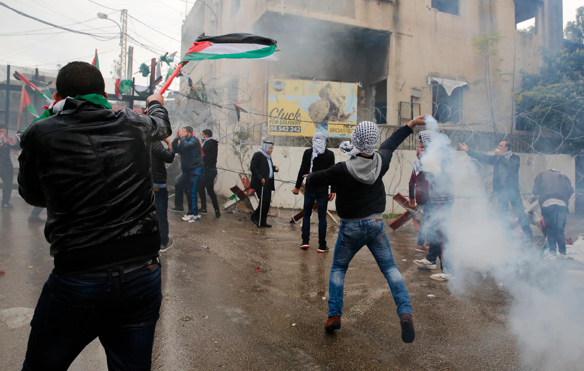En demonstrant kaster tilbake en tåregassgranat som ble skutt mot deltagerne i protesten av libanesisk opprørspoliti. Foto: AP/NTB scanpix
