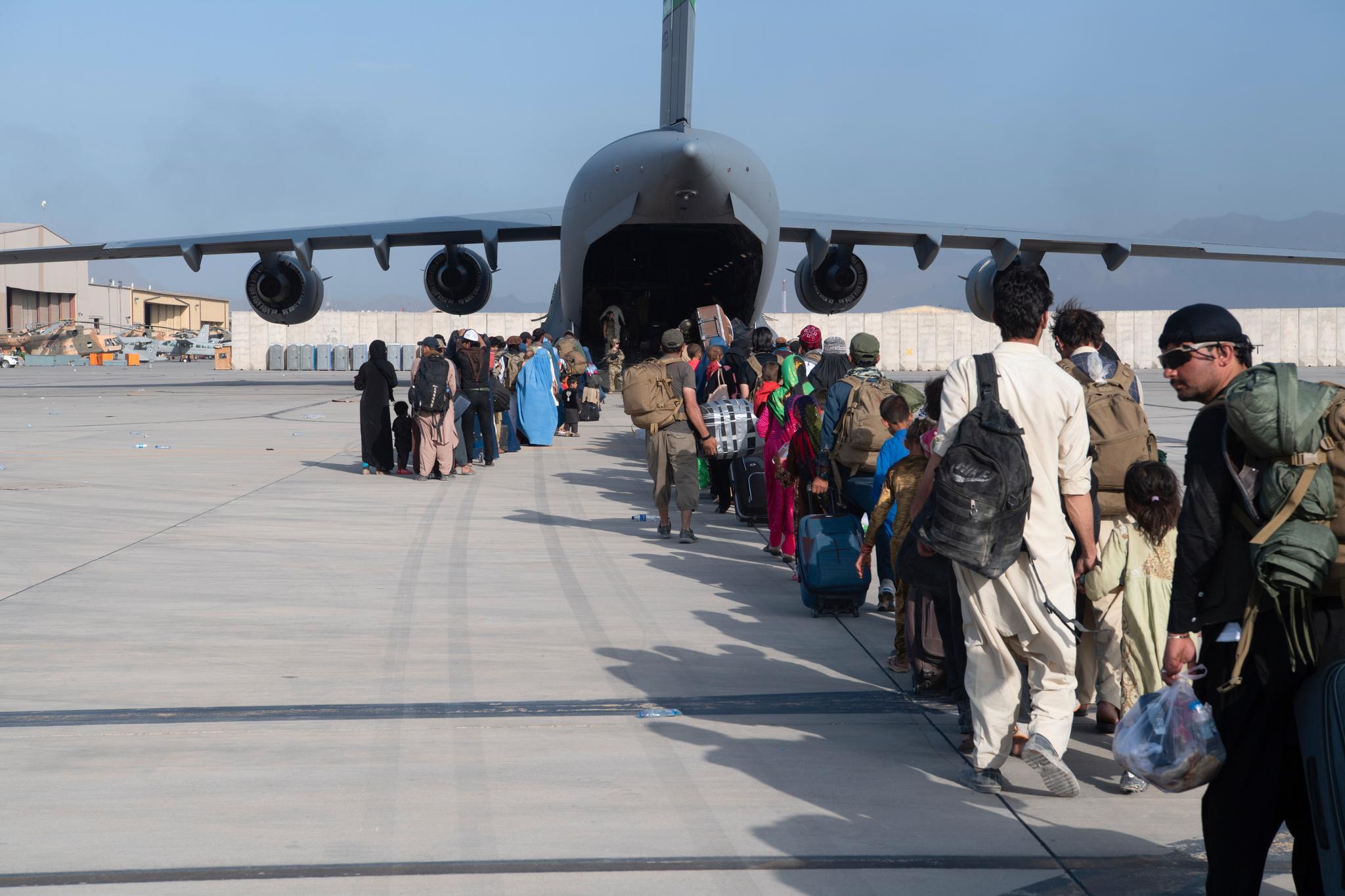 Afghanere i kø for å gå om bord i et amerikansk militærfly. Taliban lover ifølge USA å la amerikanere og afghanere i faresonen å forlate Afghanistan også etter 31. august. 