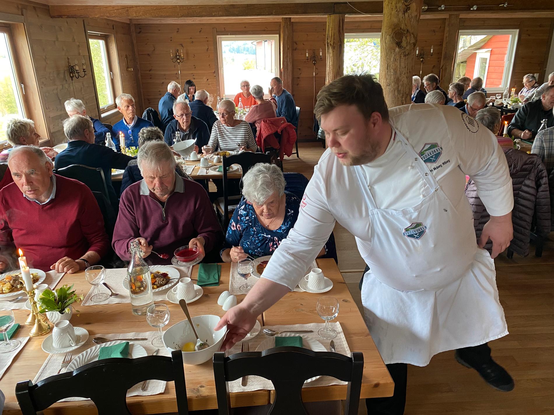 Joakim Moberg Wiborg er alt i gang på Sjernarøytunet. Her serverer han middag til eit 50-tals pensjonistar som har hatt ein rundtur på Sjernarøyane med buss frå Ingvars Reiser.