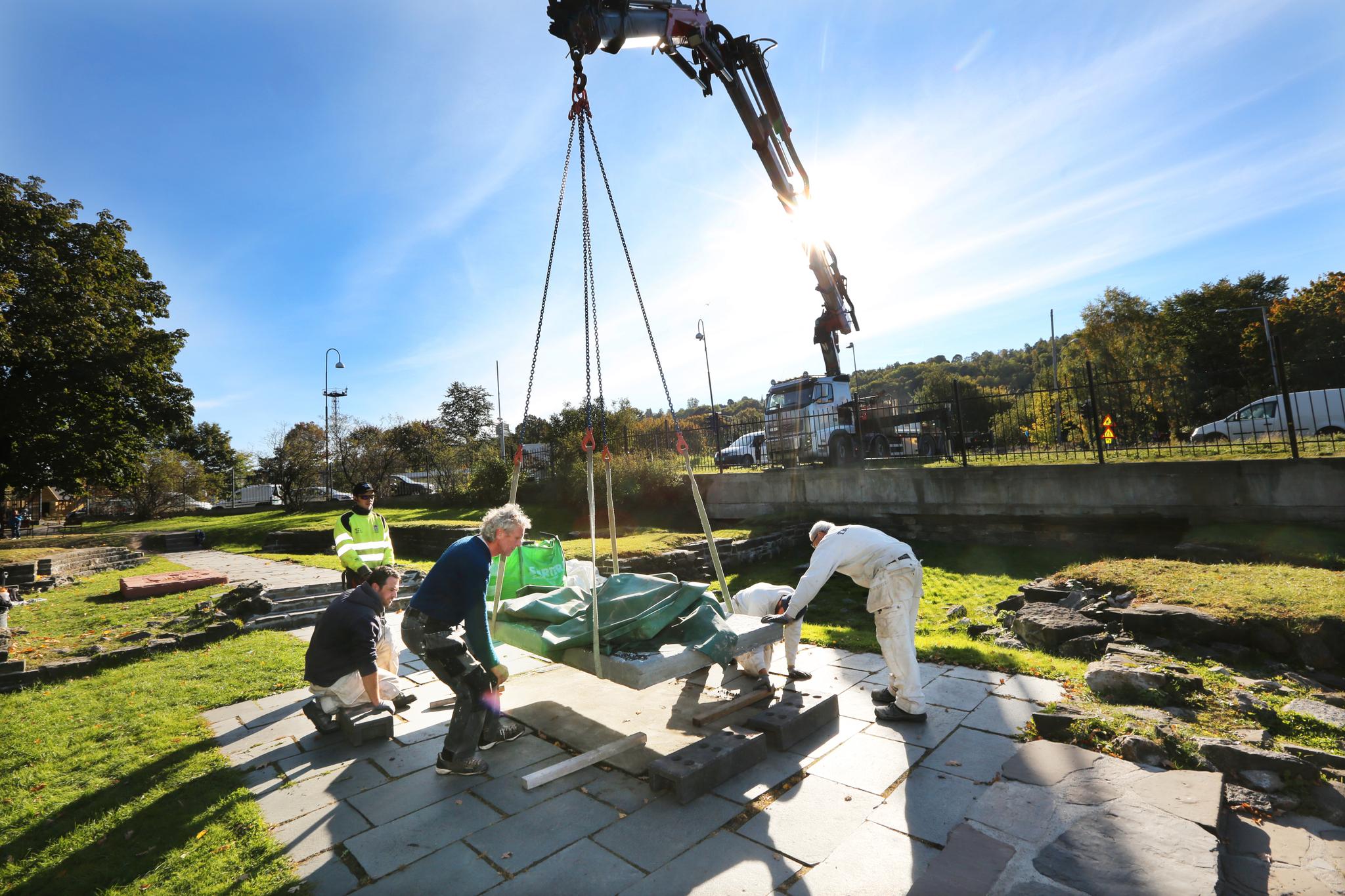 Gravsteiner heises på plass: Med en vekt på opp ttil 1,8 tonn ble nylig nye kopier av de store gravsteinene forsiktig heist på plass i Ruinparken i Gamlebyen.