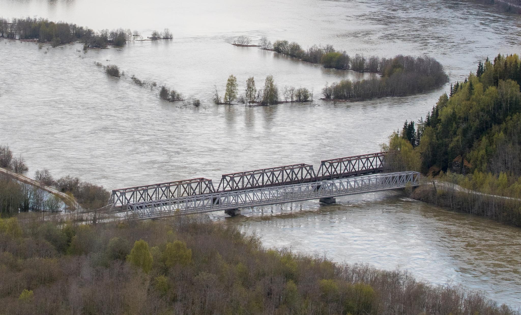 Dette bildet viser de to broene på Ringebu under flommen i mai 2018. Den nyeste, som har rast sammen, ligger foran i bildet.