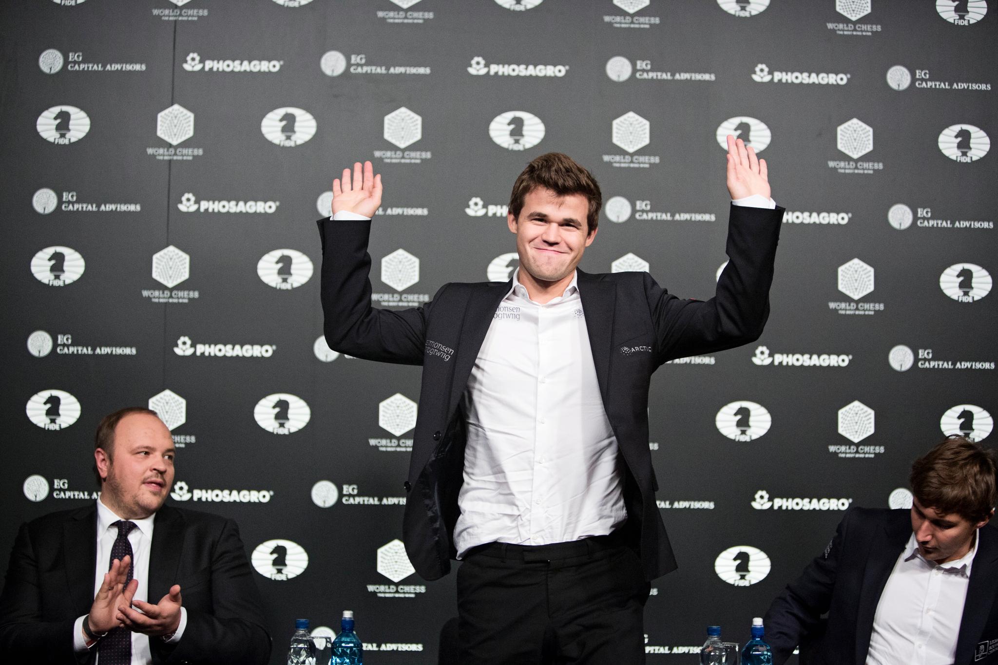 Her takker Magnus Carlsen for applausen etter VM-seieren i New York. Til høyre sitter en skuffet Sergej Karjakin.