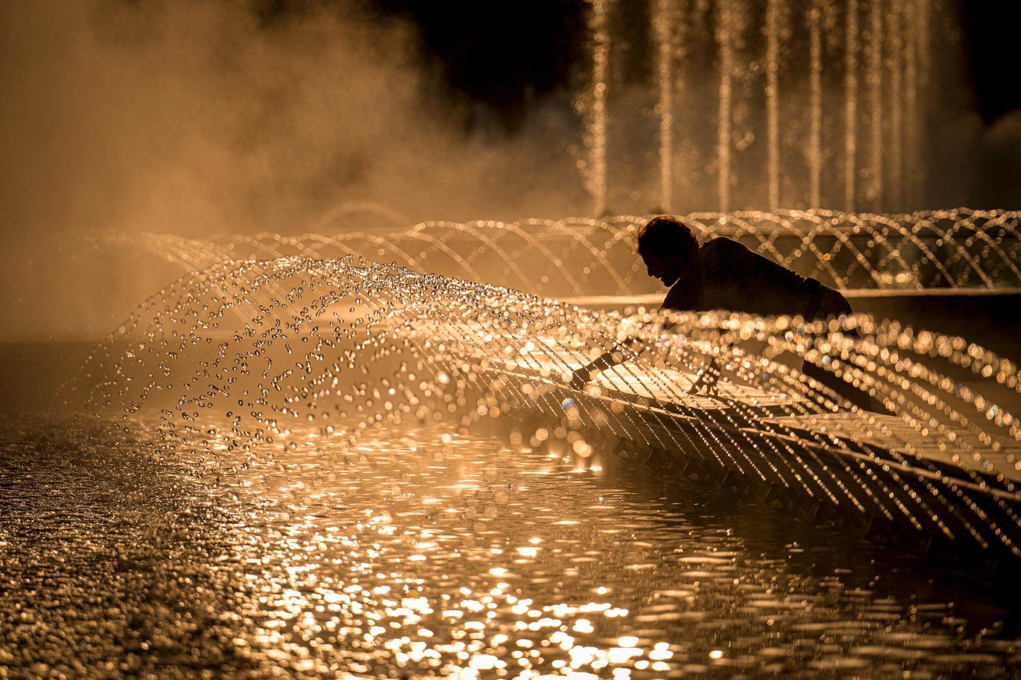 En mann kjøler seg ned i en fontene i Romanias hovedstad Bucuresti. Nå er en ny hetebølge på vei. 