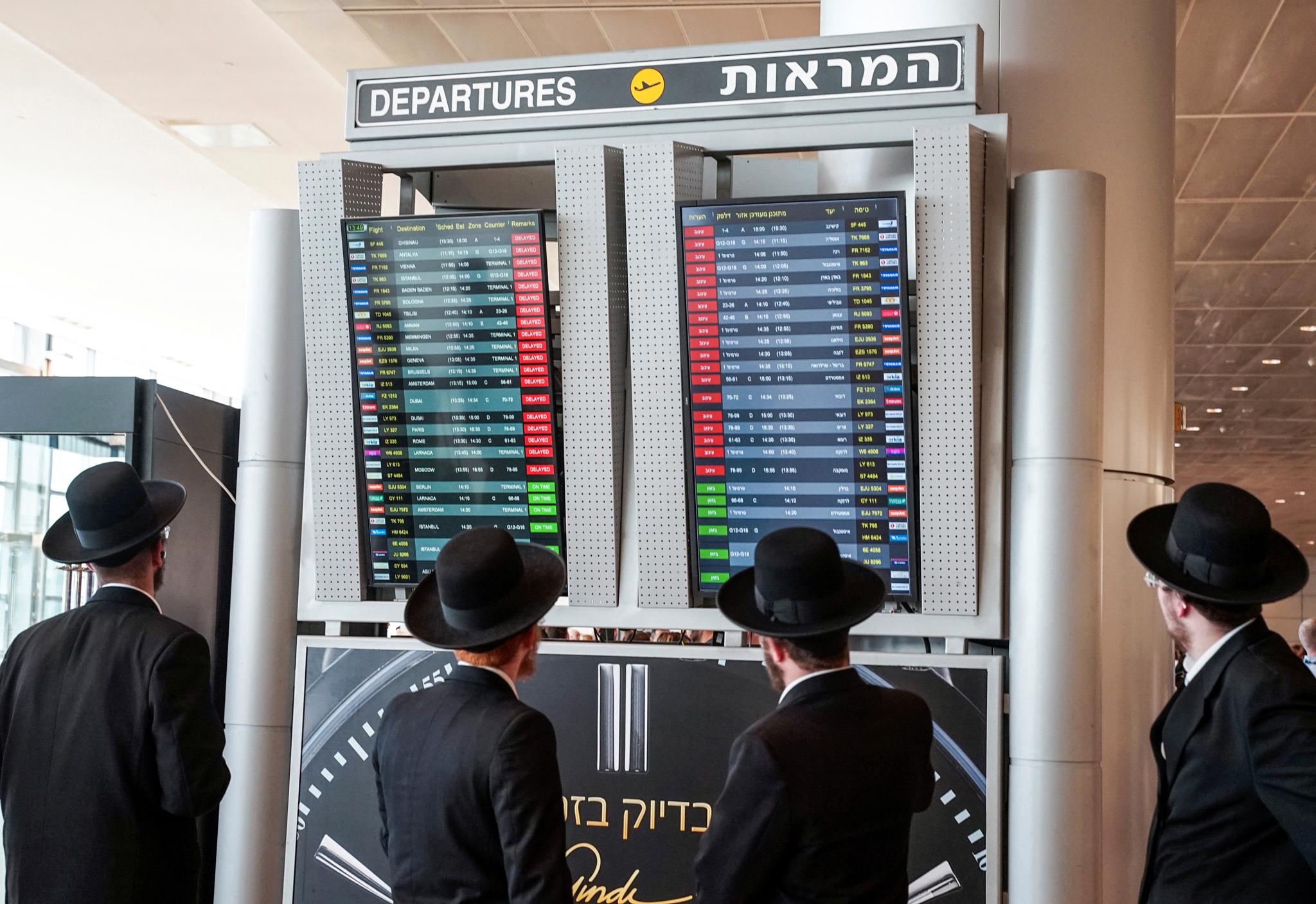 Reisende ser på oversikten over utsatte flyvninger på Ben Gurion internasjonale flyplass utenfor Tel Aviv.