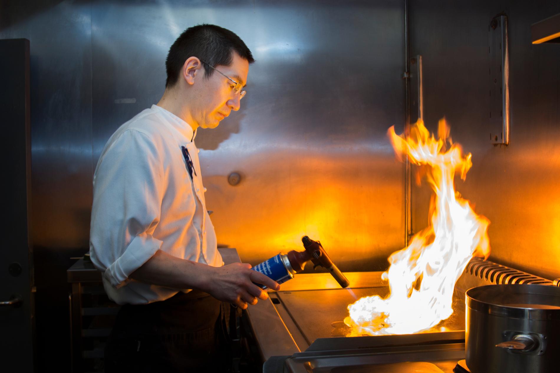 Kjøkkensjef Shintaro Hasegawa tilbereder flambert squash på kjøkkenet. Foto: Magnus Nødland Skogedal