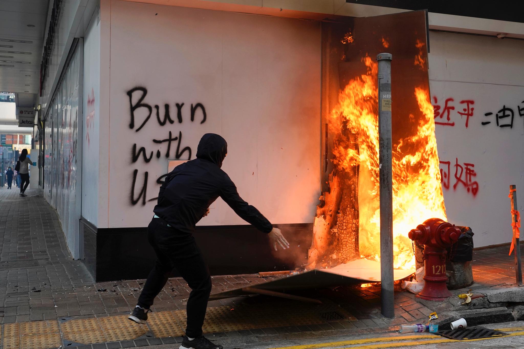 Maskerte demonstranter satte fyr på barrikader, butikker og andre bygninger i Hongkong mandag. 