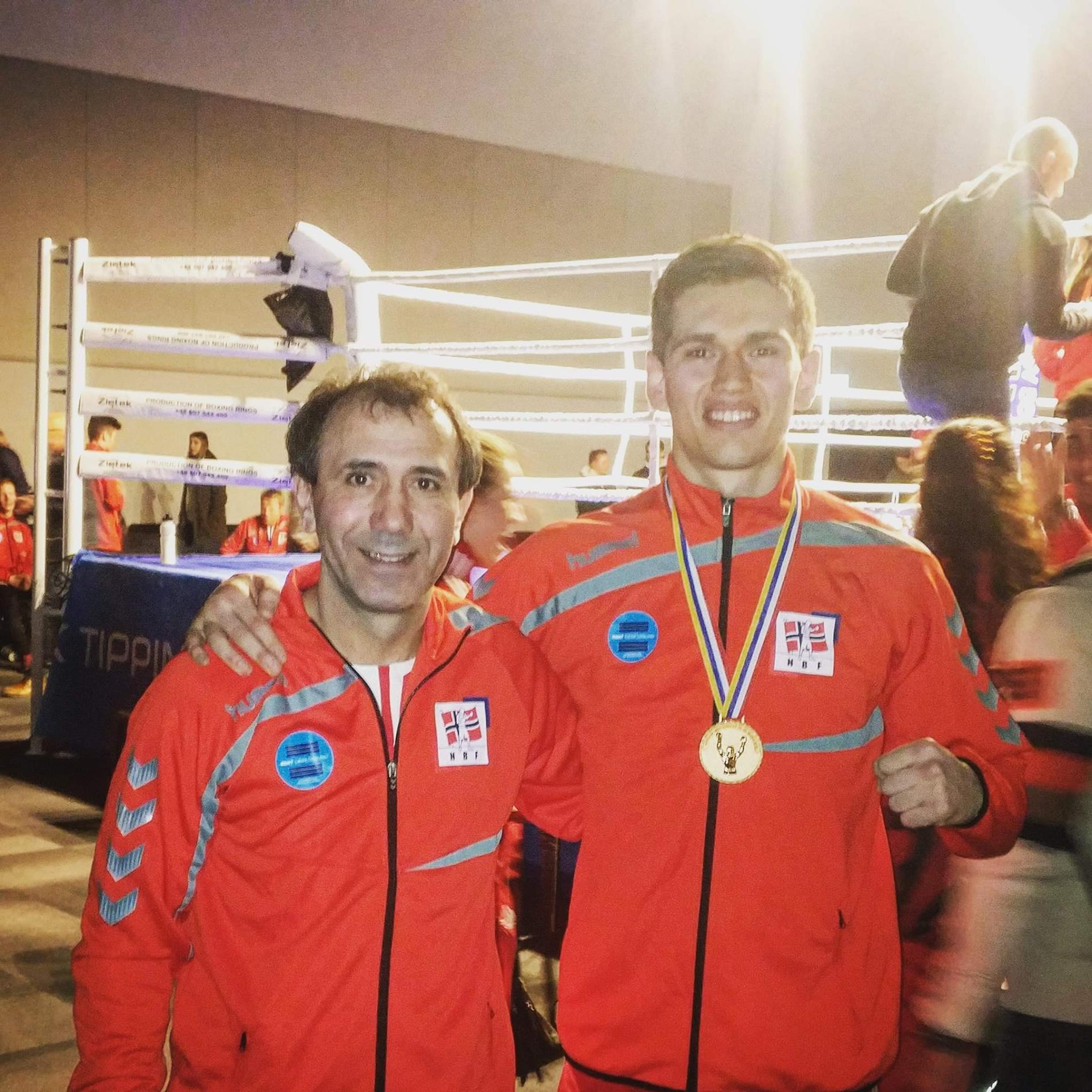 Mindaugas poserer stolt med gullmedaljen han fikk under Nordisk mesterskap i år. Ved siden av står hovedtreneren Zyandi Arsaev, som er tidligere russisk og tsjetsjensk mester i boksing.