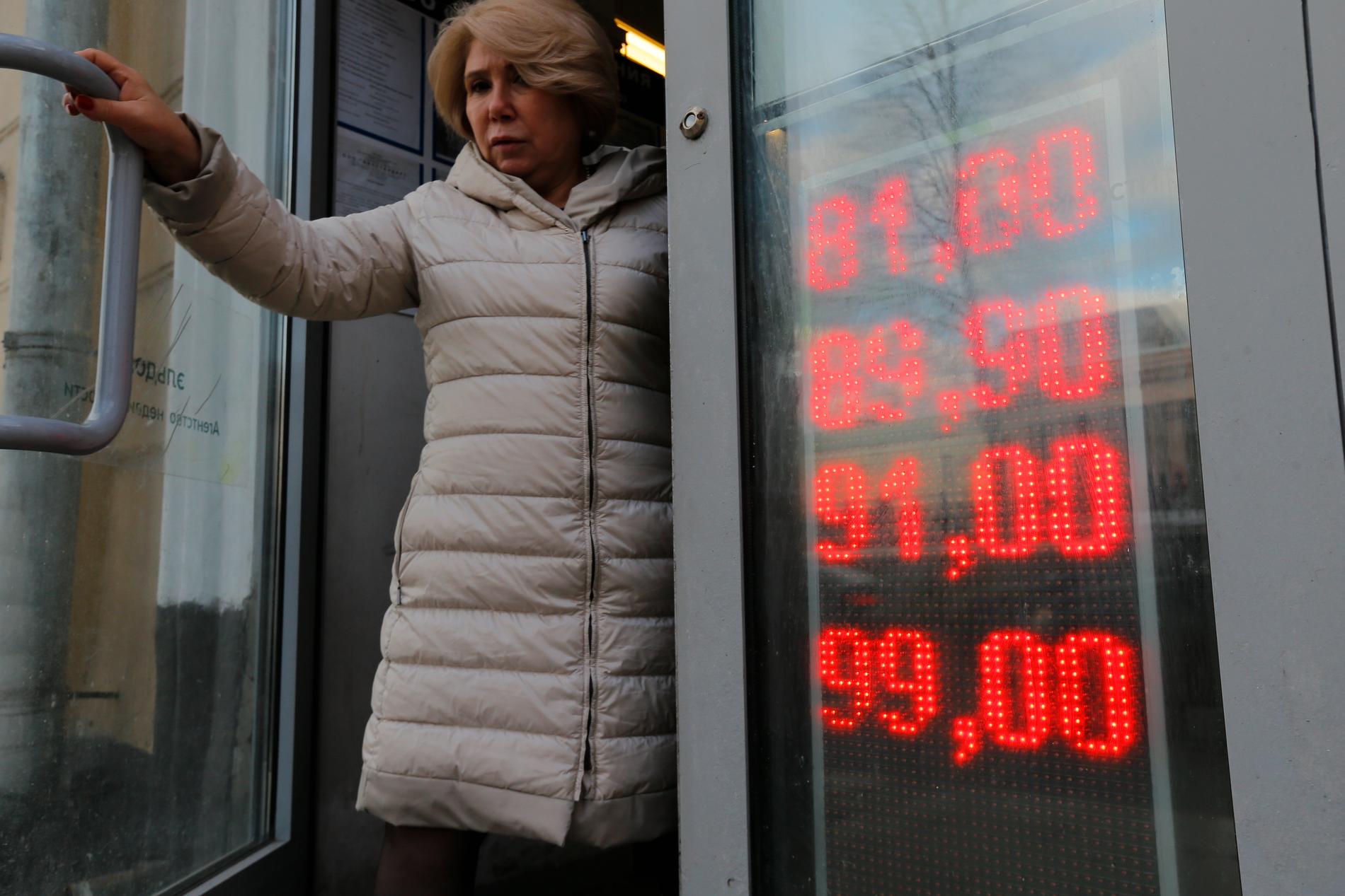 Valutaen er også i stort fall. Verdien på russiske rubler falt 9 prosent målt mot amerikansk dollar i morgentimene. Her forlater en kvinne et vekslingskontor i Moskva torsdag. 