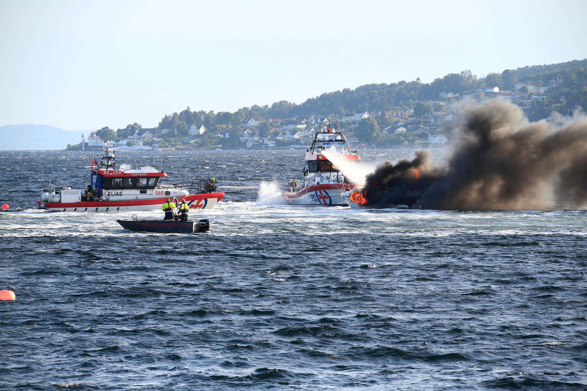 Flere redningsbåter jobbet for å få opp den savnede personen fra vannet og for å slukke brannen.