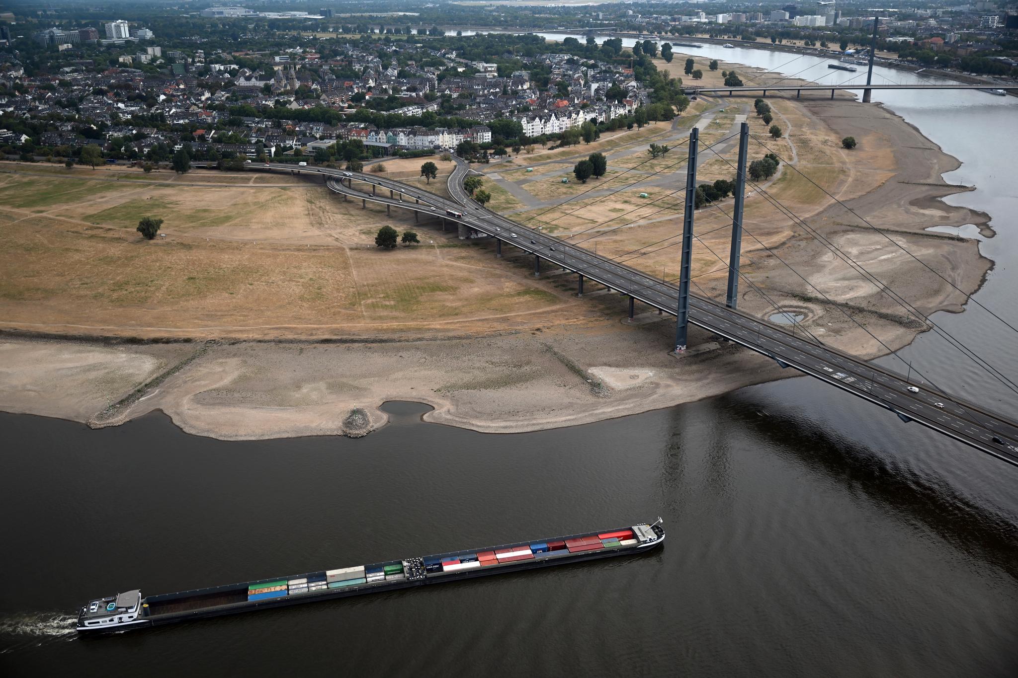 Vannstanden i Rhinen er nå så lav at den viktige elvetransporten kan måtte stanses på enkelte strekninger. Her er en lastelekter på vei forbi Düsseldorf. 