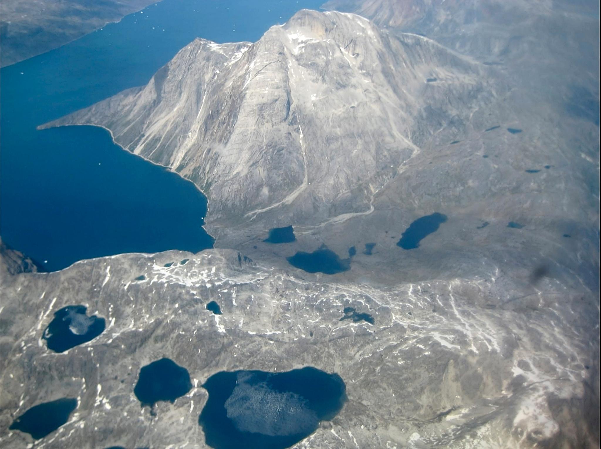 Bildet viser smeltevannsinnsjøer på kanten av en iskalott på Nunatarssuk på Grønland, 22 juni 2019.
