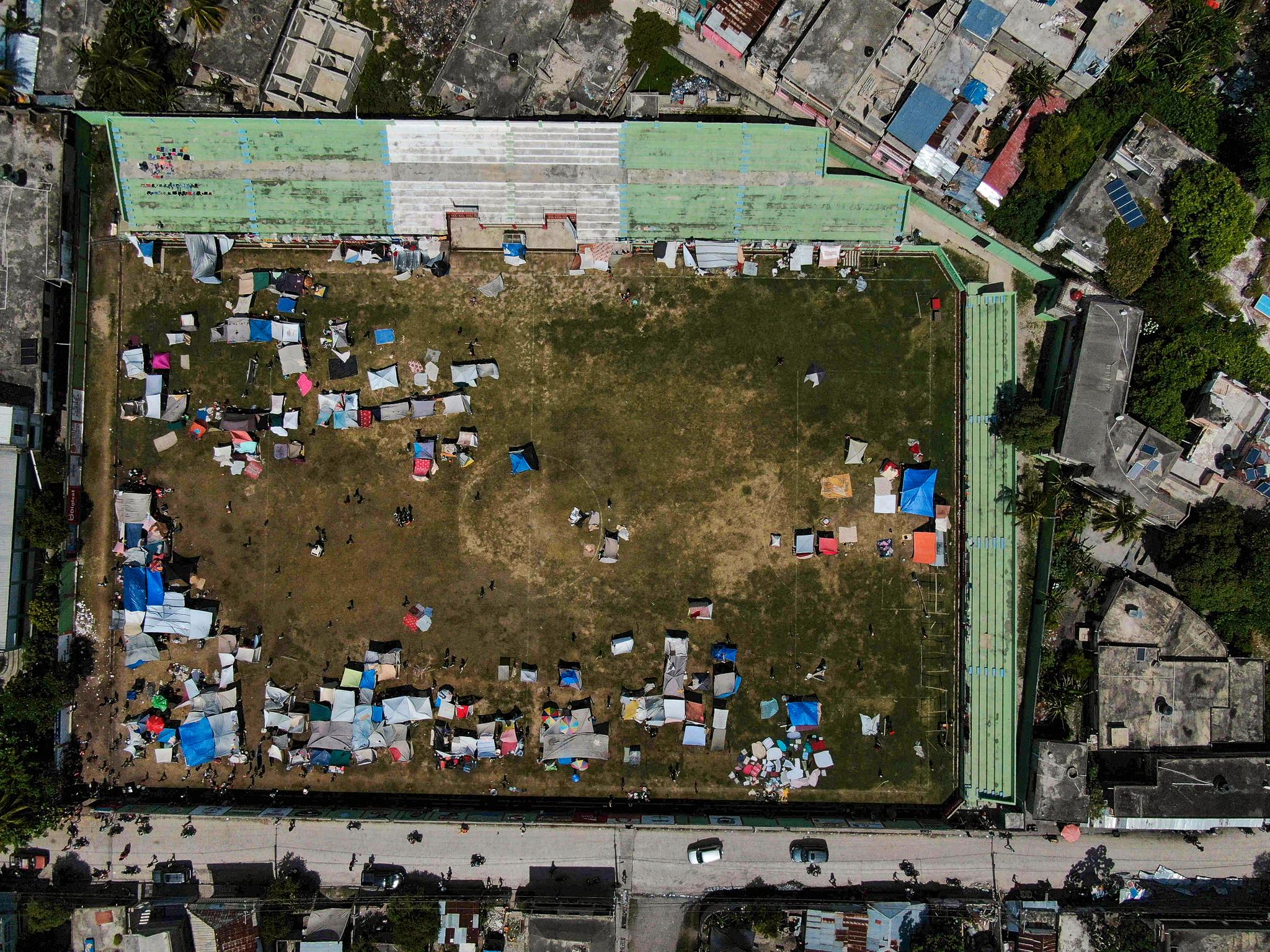 Bildet viser folk som har flyttet ut på en fotballbane i Les Cayes etter at boligene deres ble ødelagt av jordskjelvet.