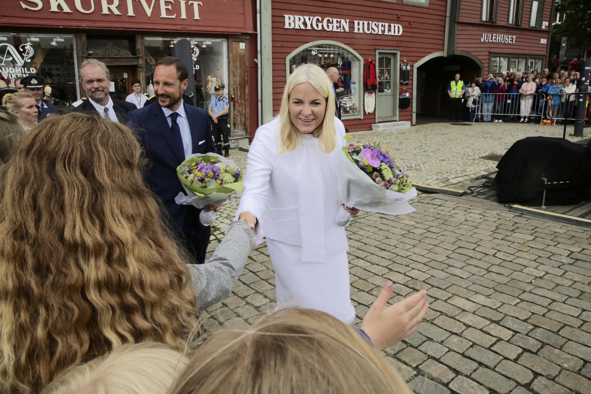 HILSEN: Kronprinsesse Mette-Marit hilser på fremmøtte. Like bak går kronsprins Haakon.