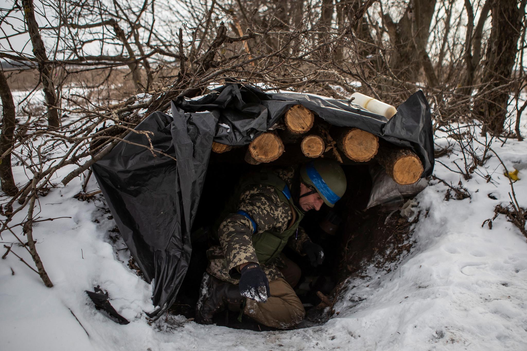 En ukrainsk soldat går inn i skyttergrav dekket med tømmer i nærheten av Vuhledar i sørlige Donetsk. Dette er et av stedene hvor angrepene er trappet kraftig opp den siste uken.