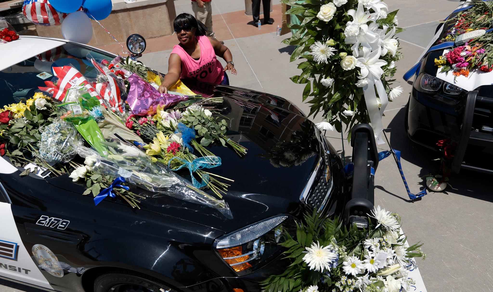 Cynthia Ware legger blomster på en politibil utenfor hovedkvarteret til Dallas-politiet fredag. Fem politifolk ble drept av en snikskytter torsdag kveld i forbindelse med en demonstrasjon mot politivold.