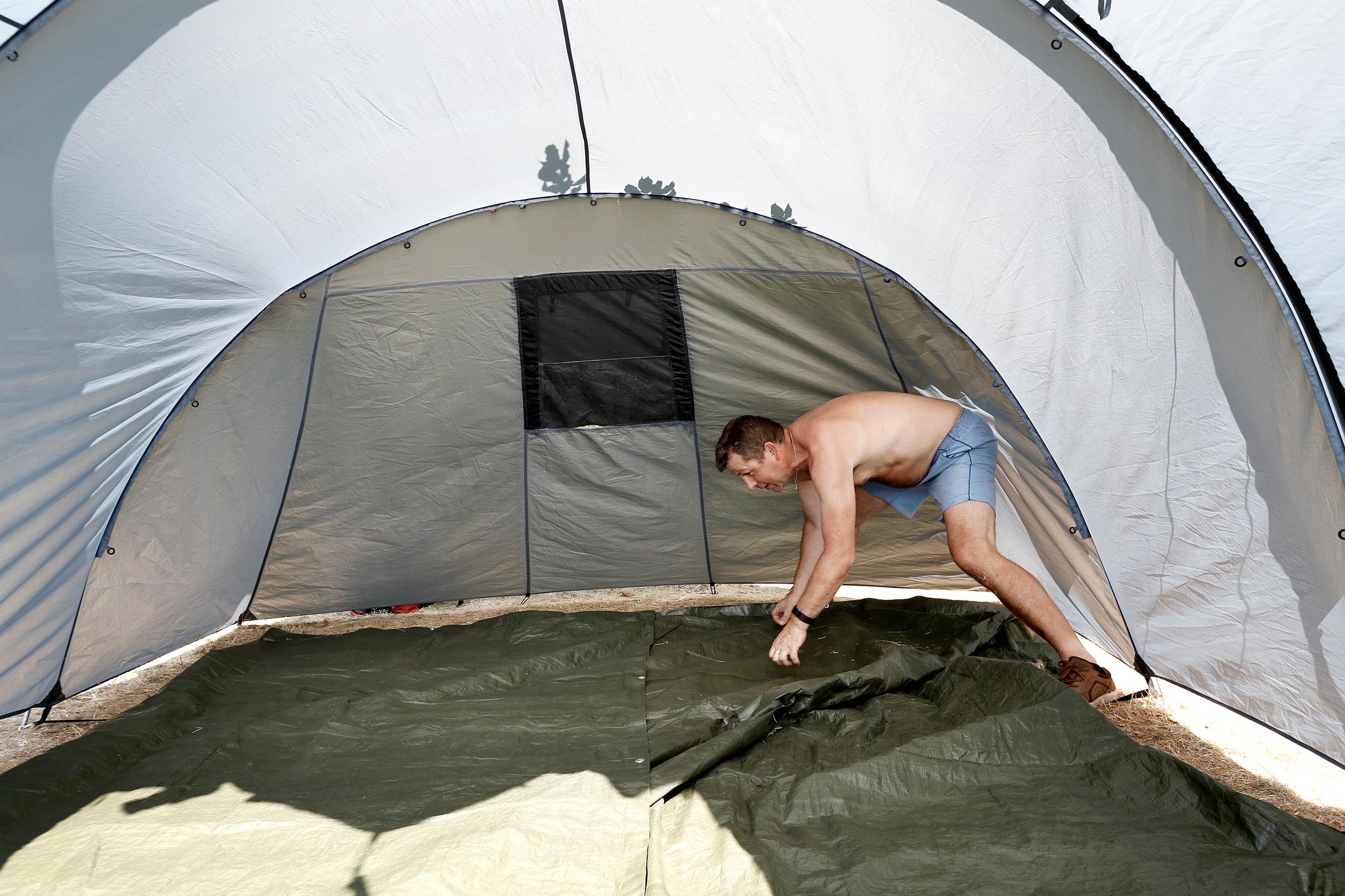 En svett Georg Andal (50) rigger opp det romslige teltet på Ekeberg Camping. Her skal han heie på Bremnes IL fra Bømlo.