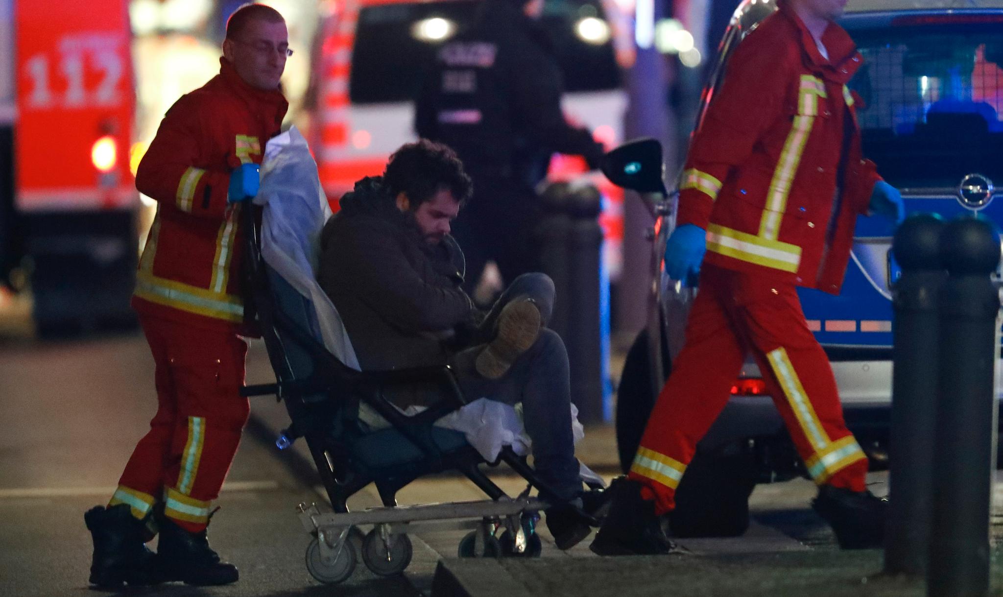 En skadet mann blir hjulpet inn i en ambulanse etter at et vogntog braste inn i folkemengden på Breitscheidplatz.