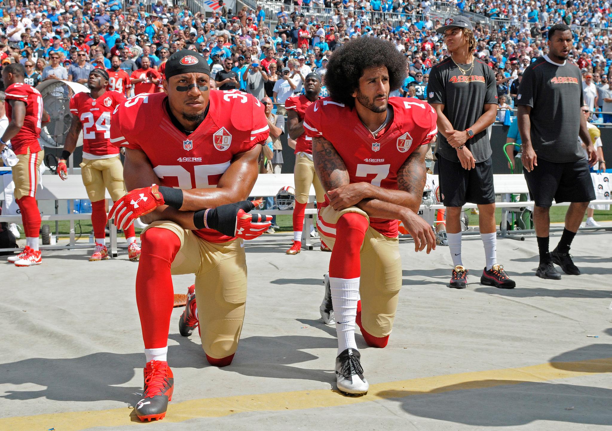 Colin Kaepernick (til høyre) startet trenden med å knele under nasjonalsangen. Her protesterer han sammen med medspiller Eric Reid.