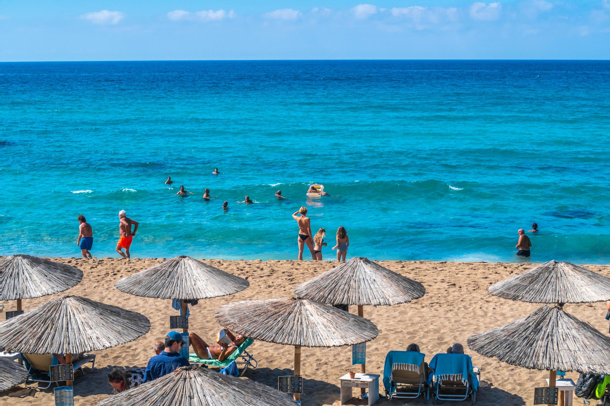 Parasoller og turister på stranden ved Falassarna på Kreta i Hellas. Nå kan nordmenn igjen dra dit på ferie.