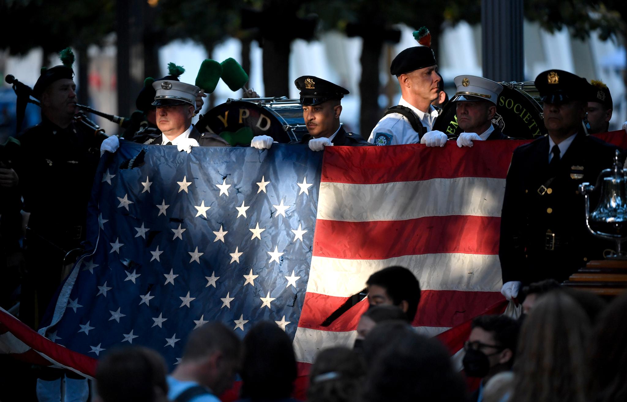 Politi og brannmannskaper fra New York bar inn et flagg som ble funnet i ruinene av tvillingtårnene etter angrepene 11. september 2001. 