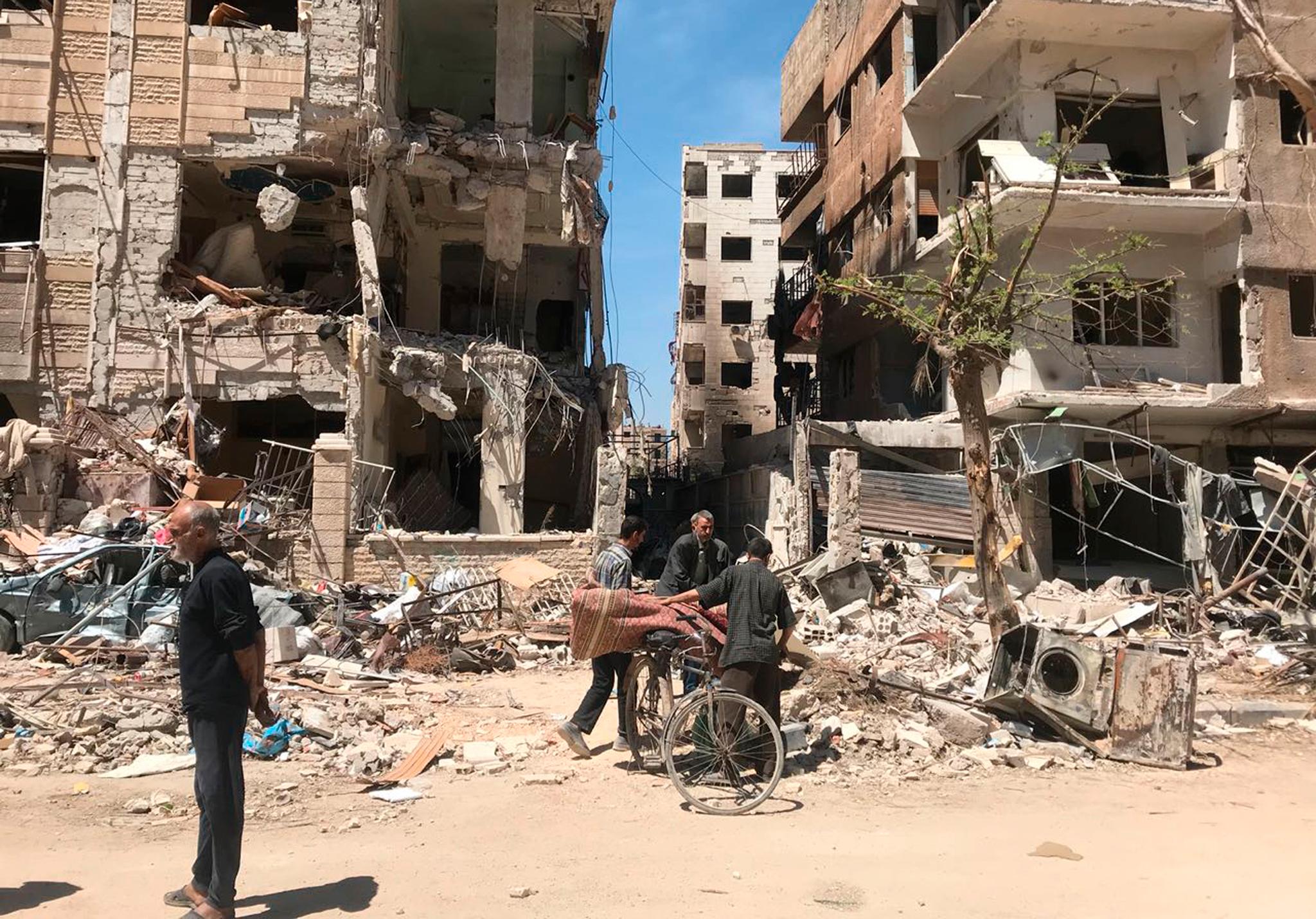 Mandag formiddag var folk ute i de bombede gatene  i Douma, nær bygninger der man mistenker at det har vært oppbevart utstyr til kjempiske våpen. 