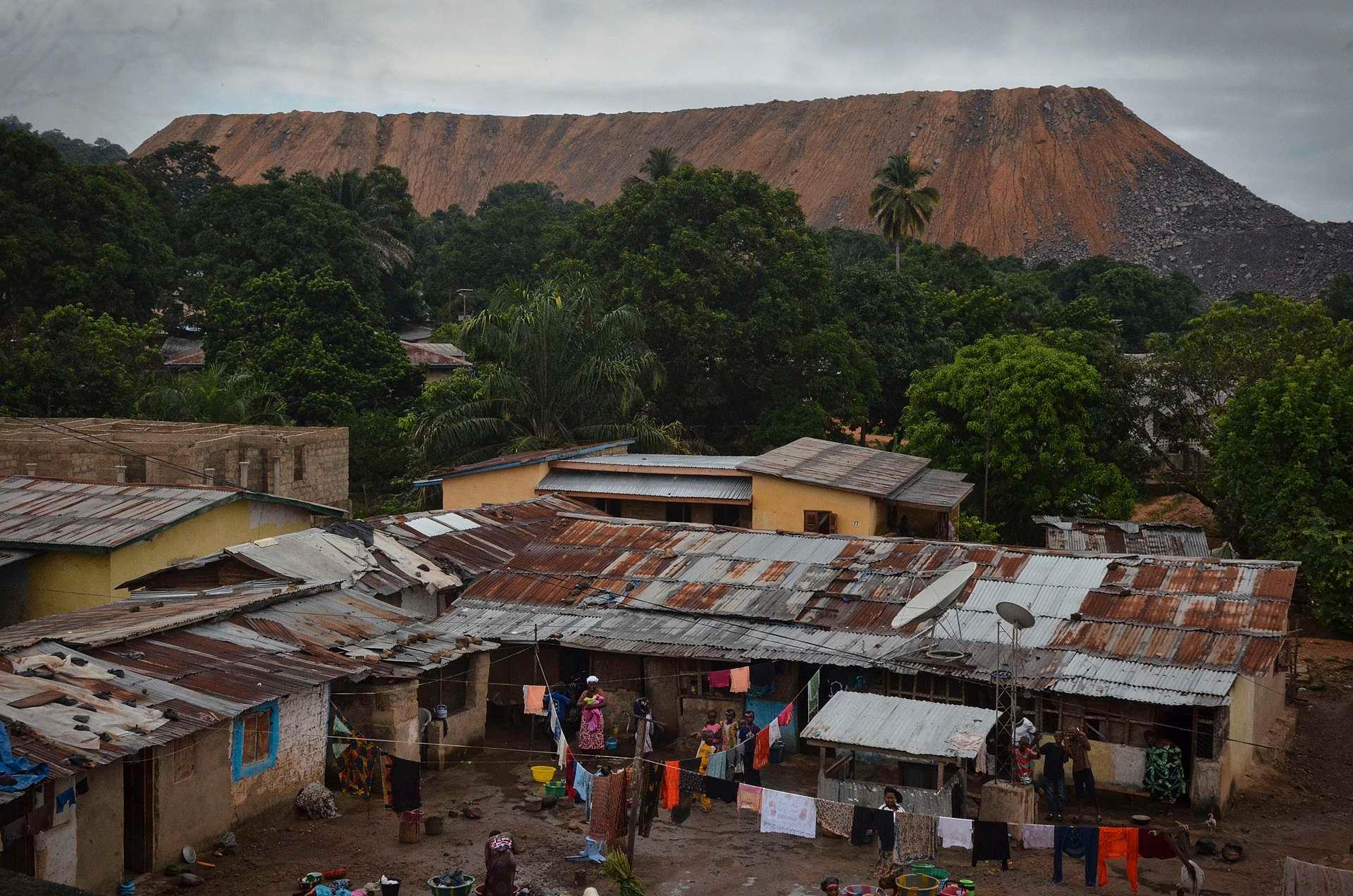 Avgangsmasse, altså stein, grus og jord, fra Koidu-gruven tårner over byen øst i Sierra Leone. Innbyggerne varsles med en sirene hver gang det skal sprenges - da er det bare å komme seg unna og vente på signalet som indikerer at det er trygt å returnere.