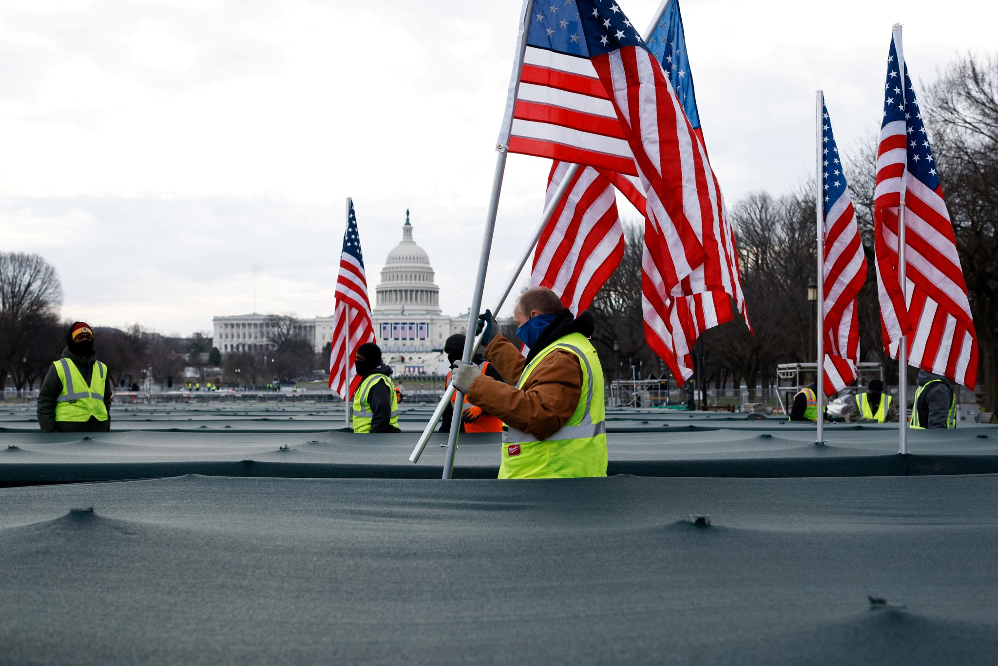 Arbeidere setter opp flagg på National Mall, som skal representere menneskene som ikke har mulighet til å delta på innsettelsen av Joe Biden på grunn av koronapandemien.
