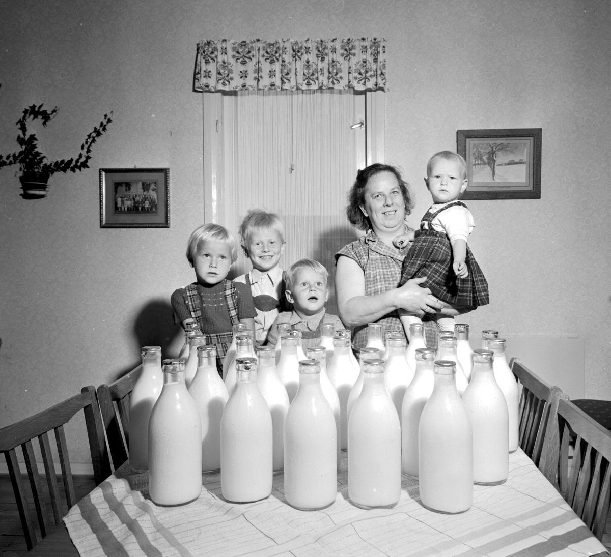Oslo 1956 – Familie med melkeflasker foran seg på bordet. 32 flasker melk bruker familien Bjølsand normalt i uken. Mor og fire barn. Foto: Sverre A. Børretzen / Aktuell / Scanpix