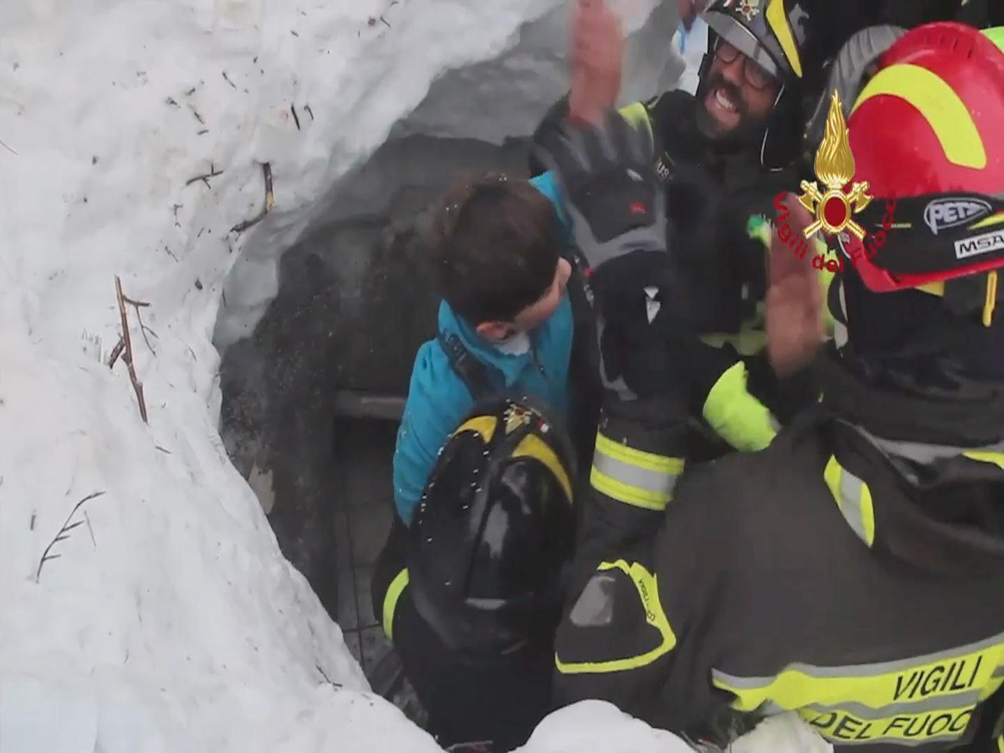 Her blir en overlevende gutt hentet ut fra snømassene.