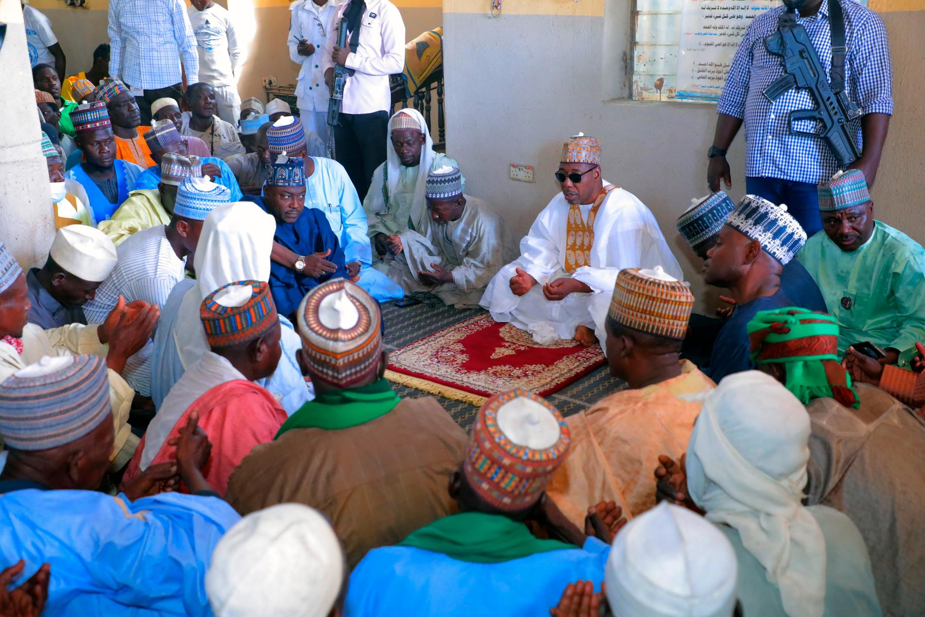 Delstaten Bornos guvernør Babagana Umara Zulum (i midten) i bønn under begravelsen for ofre etter lørdagens massakre nordøst i Nigeria. 