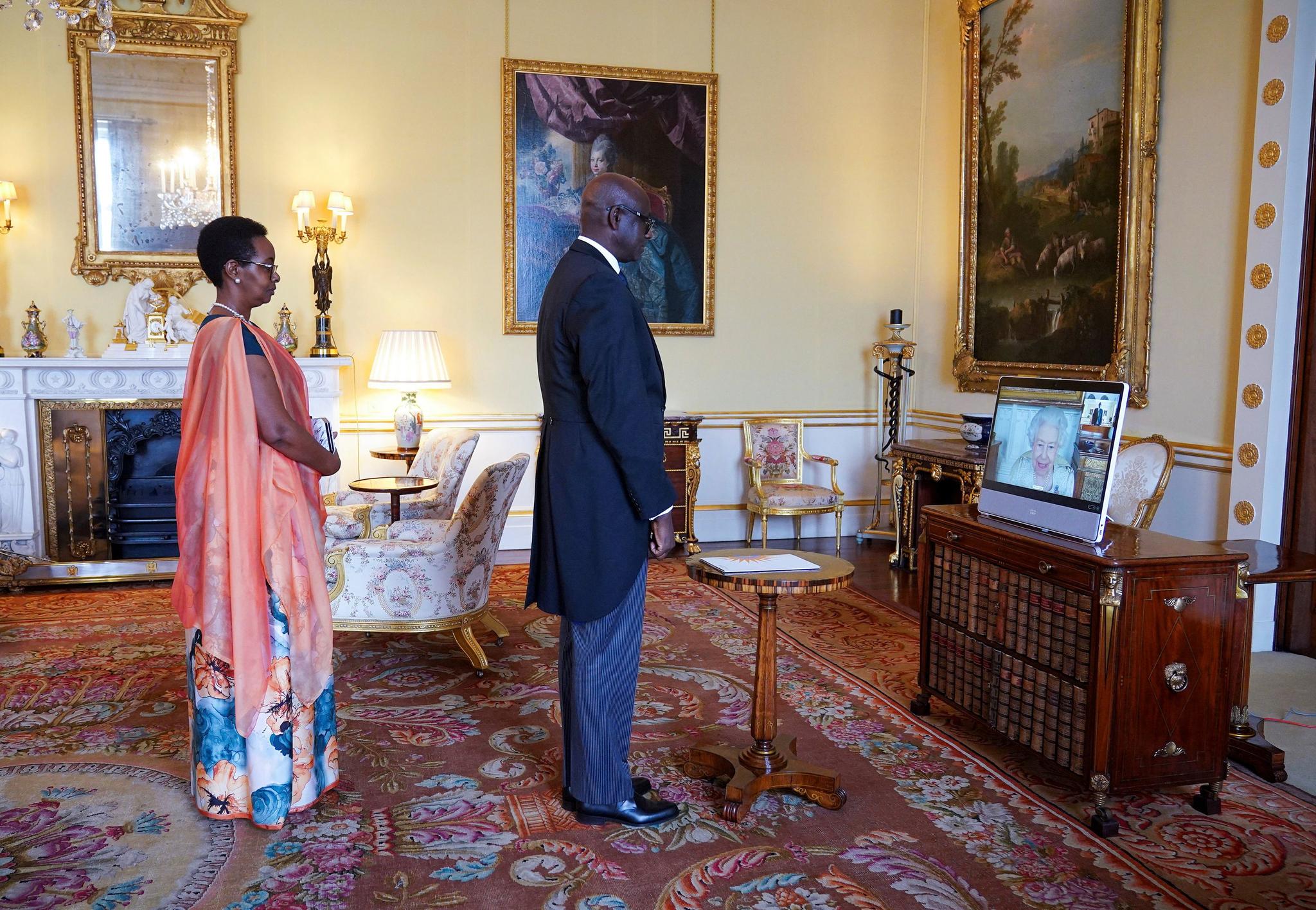 Storbritannias dronning Elizabeth II (på skjermen til høyre) satt i Windsor Castle da Rwandas høykommissær Johnston Busingye og hans kone Phoebe Murerwa var på audiens i Buckingham Palace fredag.