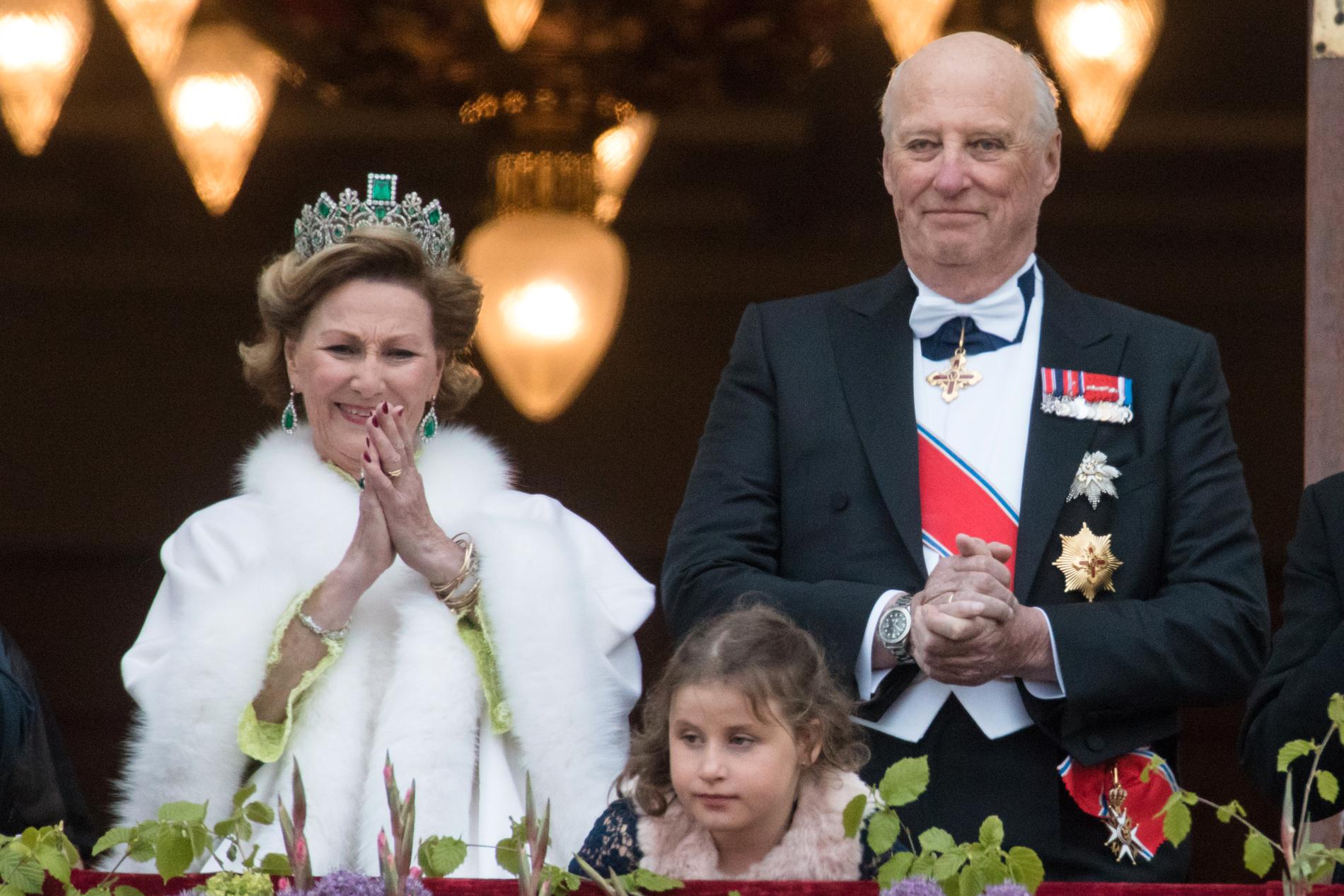 Dronning Sonja (t.v.), Emma Tallulah Behn og kong Harald. Kongeparet med kongelige gjester hilser publikum fra slottsbalkongen i anledning sin 80-årsfeiring.
Foto: Audun Braastad / NTB scanpix