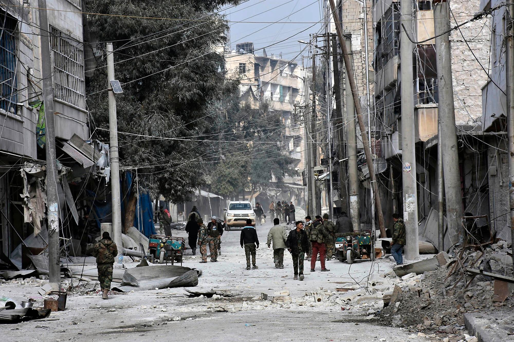Dette bildet tatt av det offisielle nyhetsbyrået SANA viser syriske soldater og sivile i gatene i Aleppo mandag 12. desember.