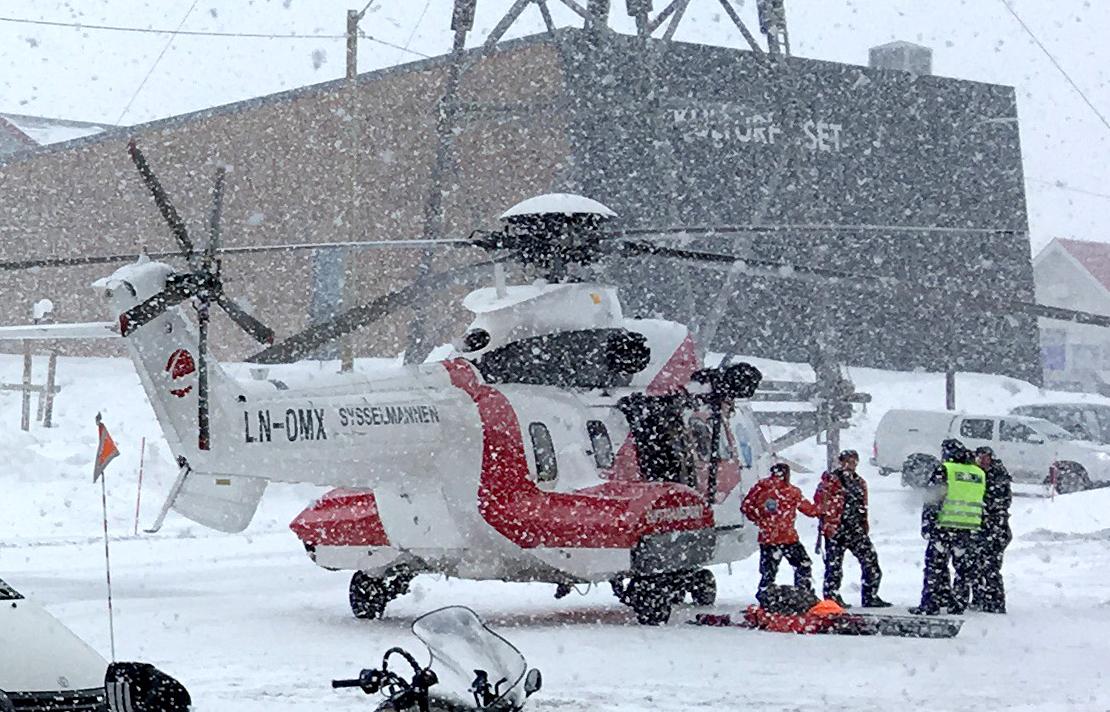 Et av redningshelikoptrene til Sysselmannen kommer her til Longyearbyen med noen av turistene som gikk gjennom isen i en råk i Tempelfjorden på Svalbard torsdag.