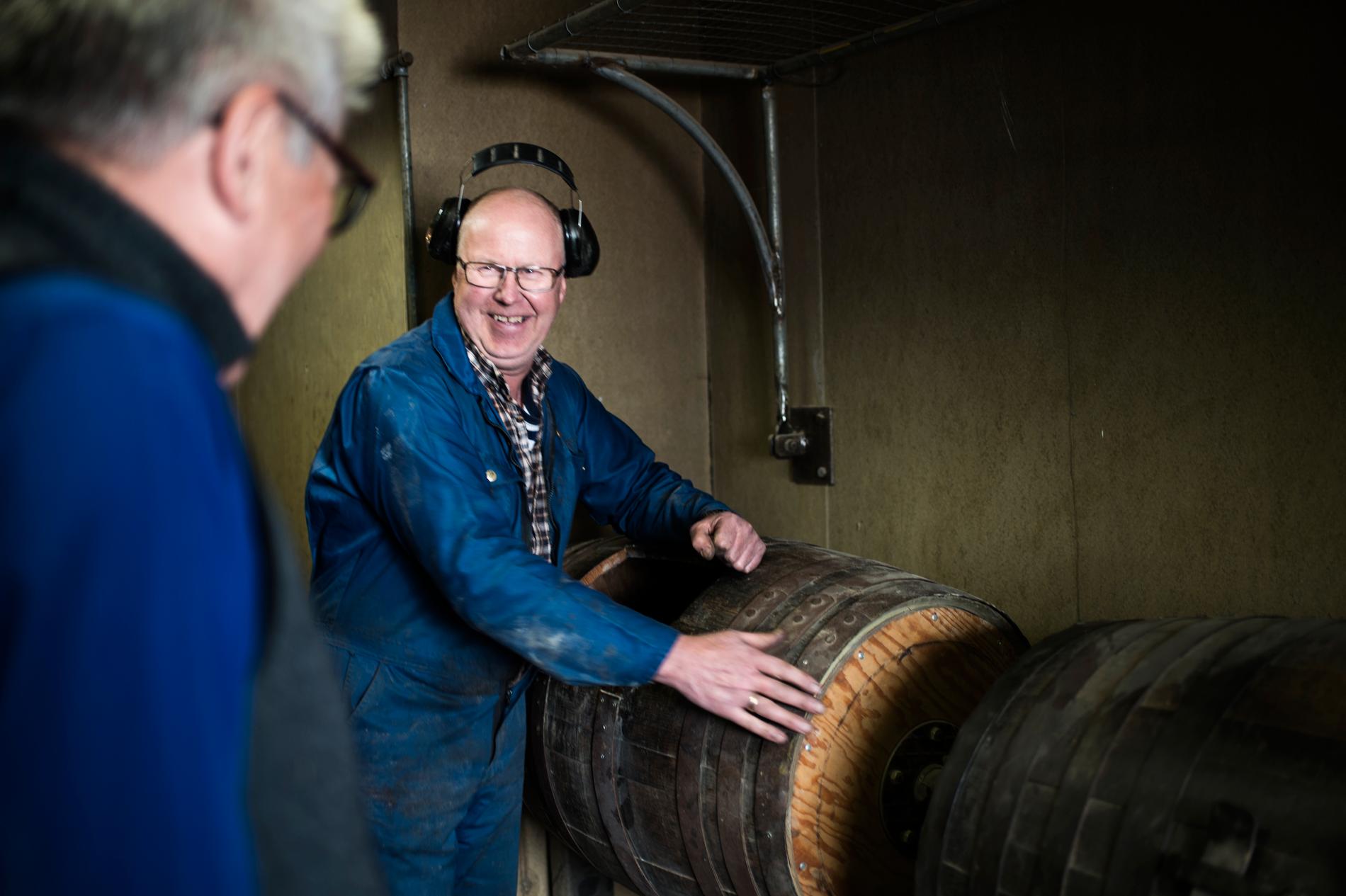 GJENBRUK: Audun Erikstad har arbeidd ved Helle knivfabrikk sidan 1973. Her viser han den gamle whiskytønna, der mange knivskaft om gangen blir romla saman med filler dynka i olje. Torodd Helle til venstre.