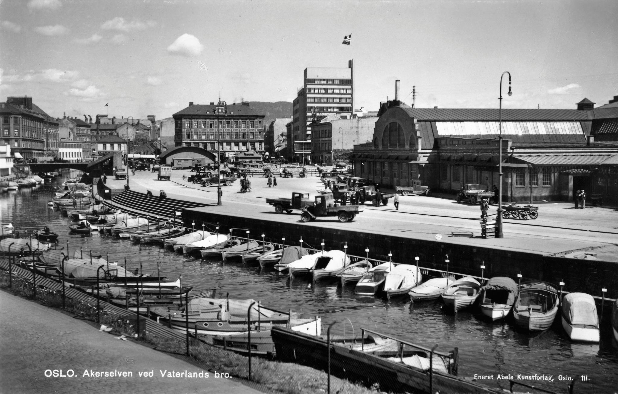 Akerselva mot Vaterlands bru med Grønlands torg og Kjøtthallen/Slaktehuset på østre (høyre) bredd. Bildet er fra ca 1935. Grønlands torg var opprinnelig et kvegtorg. Det ble grunnlagt i 1860, og ble kalt «Kutørjet». I 1970-åra ble det tatt i bruk som bussterminal, og torget ble brukt til dette inntil den nye bussterminalen i Galleri Oslo åpnet i 1989.