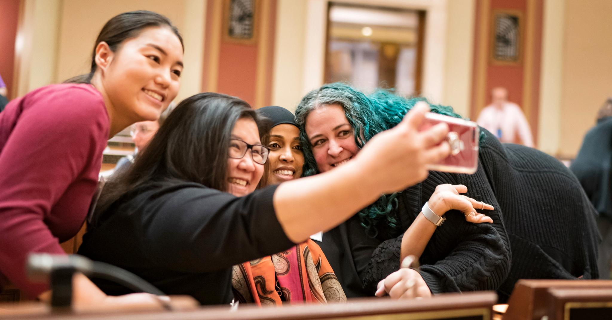 Hodan Hassan (midten) tar en selfie etter at å bli valgt til delstatsforsamlingen i Minnesota i november 2018. Hun representerer et område som har vært første stopp for mange bølger av innvandrere, også fra Norge. 