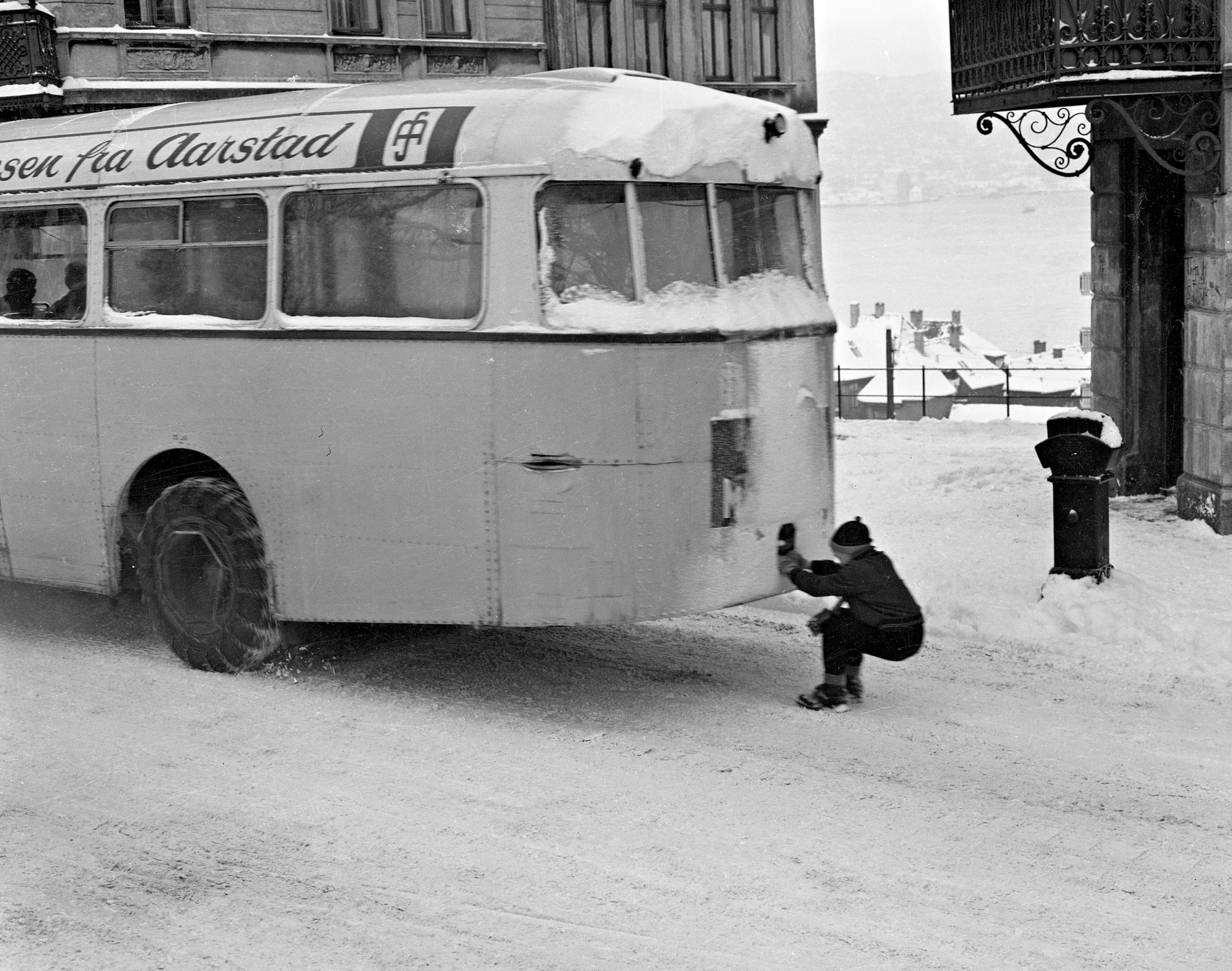 KJANKET: Over hele byen kjanket kjuaguttene busser og lastebiler når snøen kom. Her har en gutt fått godt tak og god gli ute i Haugeveien.