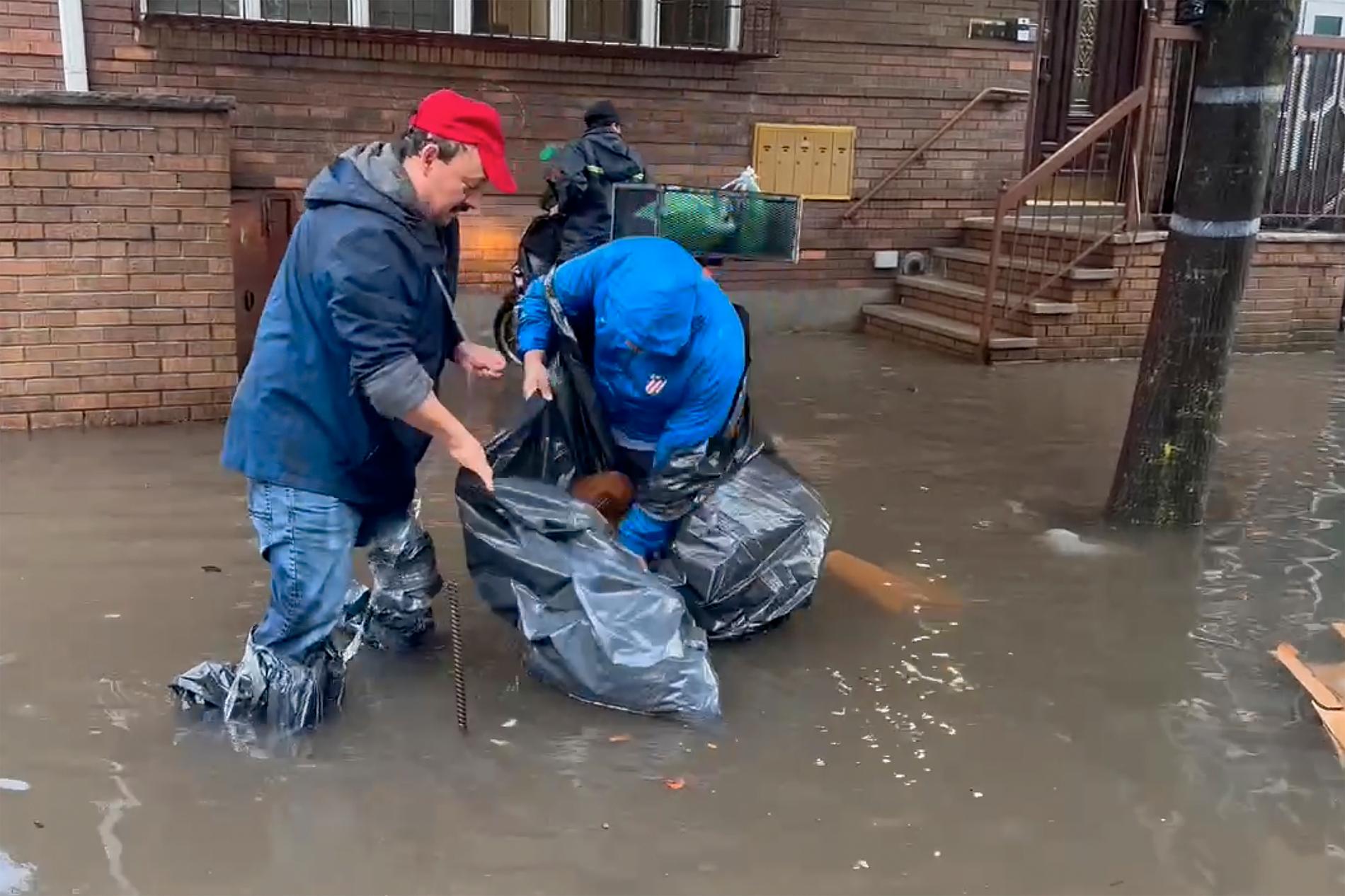 Kommunearbeidere i Brooklyn forsøker å rense i kummer som er oversvømt fredag. 