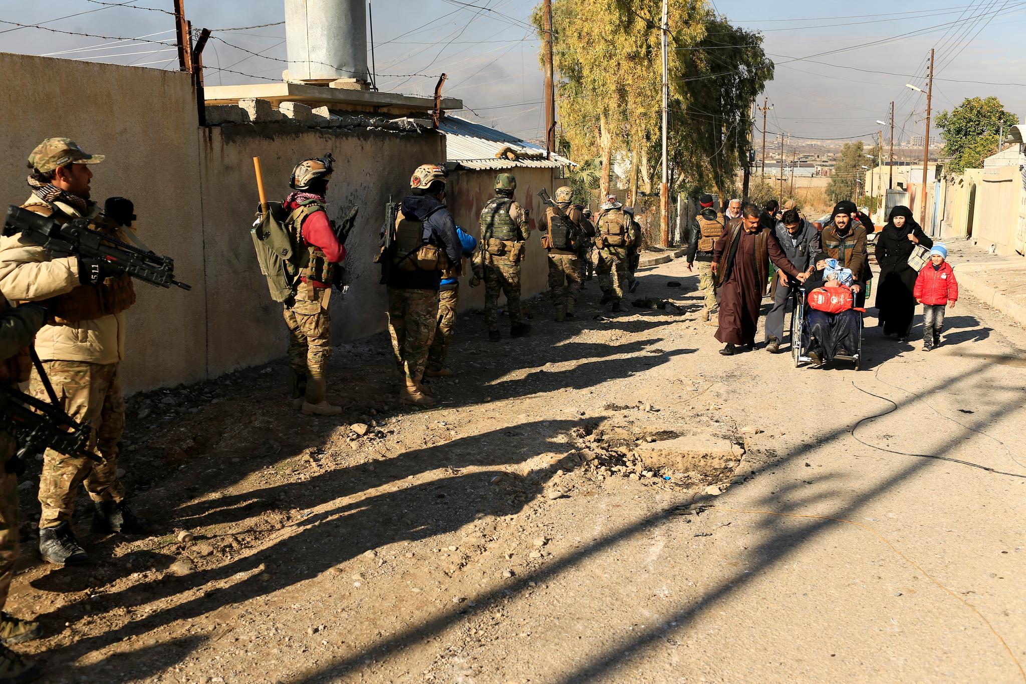 Irakske soldater møter sivile som forsøker å flykte fra kamphandlingene.