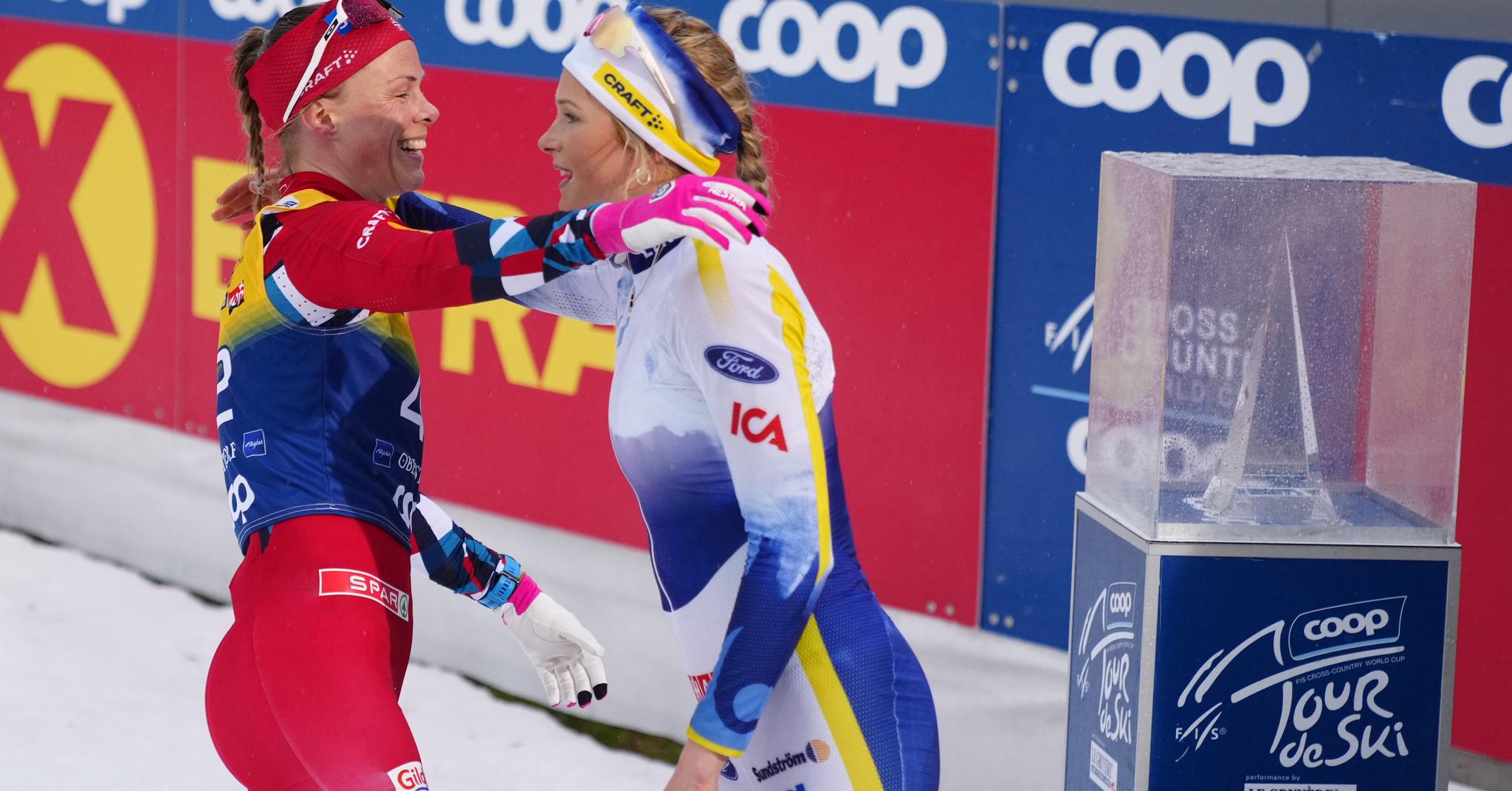 Anne Kjersti Kalvå gratulerer Frida Karlsson med seieren på 10-kilometeren i klassisk stil i Oberstdorf.
