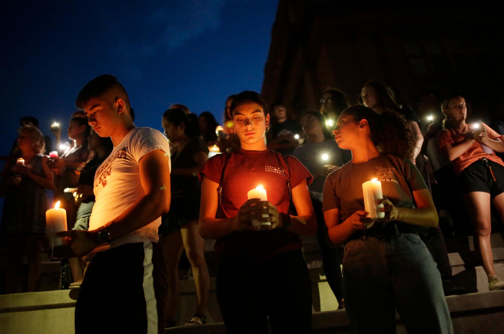 Samuel Lerma, Arzetta Hodges and Desiree Qunitana holder lys under en markering ved El Paso High School lørdag kveld, lokal tid. 