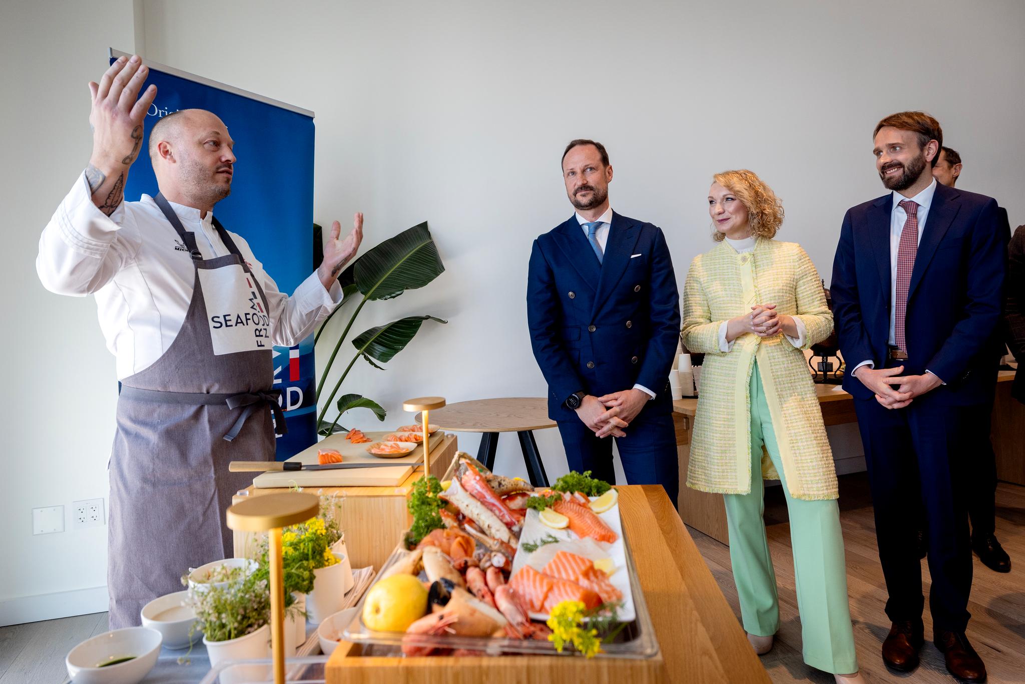 Kronprins Haakon, digitaliseringsminister Karianne Tung og næringsminister Jan Christian Vestre hører stjernekokken Christopher Haatuft fortelle om restaurantplaner i San Francisco.