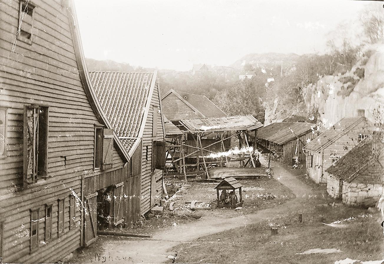 Bak verftets boder lå en rekke bygninger, noen av dem flere hundre år gamle. Til høyre smiene og spillet. Slippen var den siste overbygde bedding i Bergen.