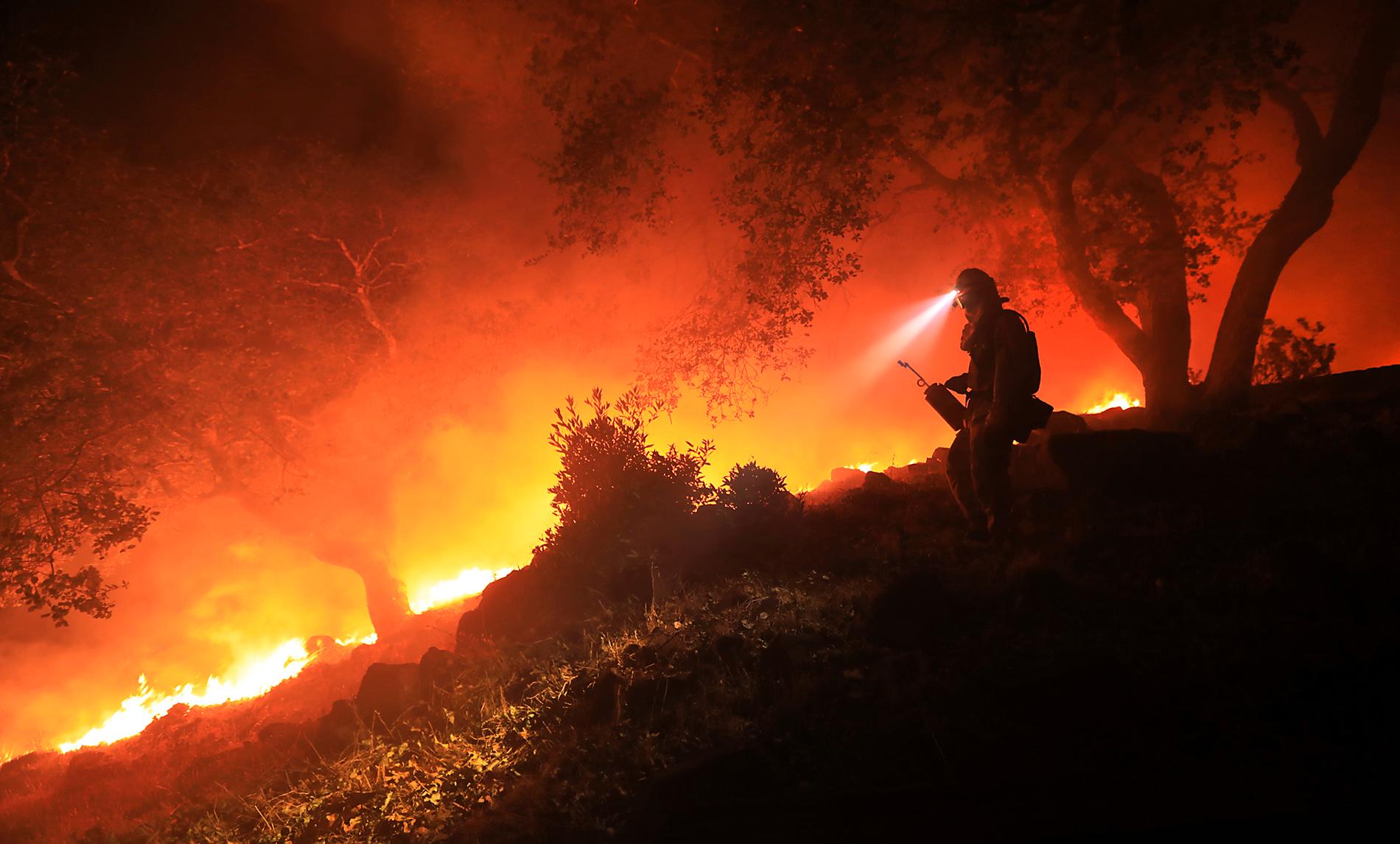 BRANN: En brannmann holder øye med flammene som blusser opp ved Sonoma Valley i California. Sterk vind i området førte til at flammene plutselig skiftet retning.