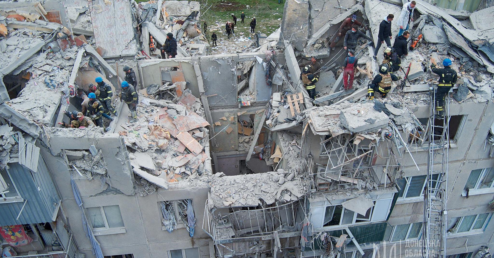 Redningsarbeidere gjennomsøker en boligblokk etter et angrep mot Slovjansk i Øst-Ukraina fredag 14. april. 
