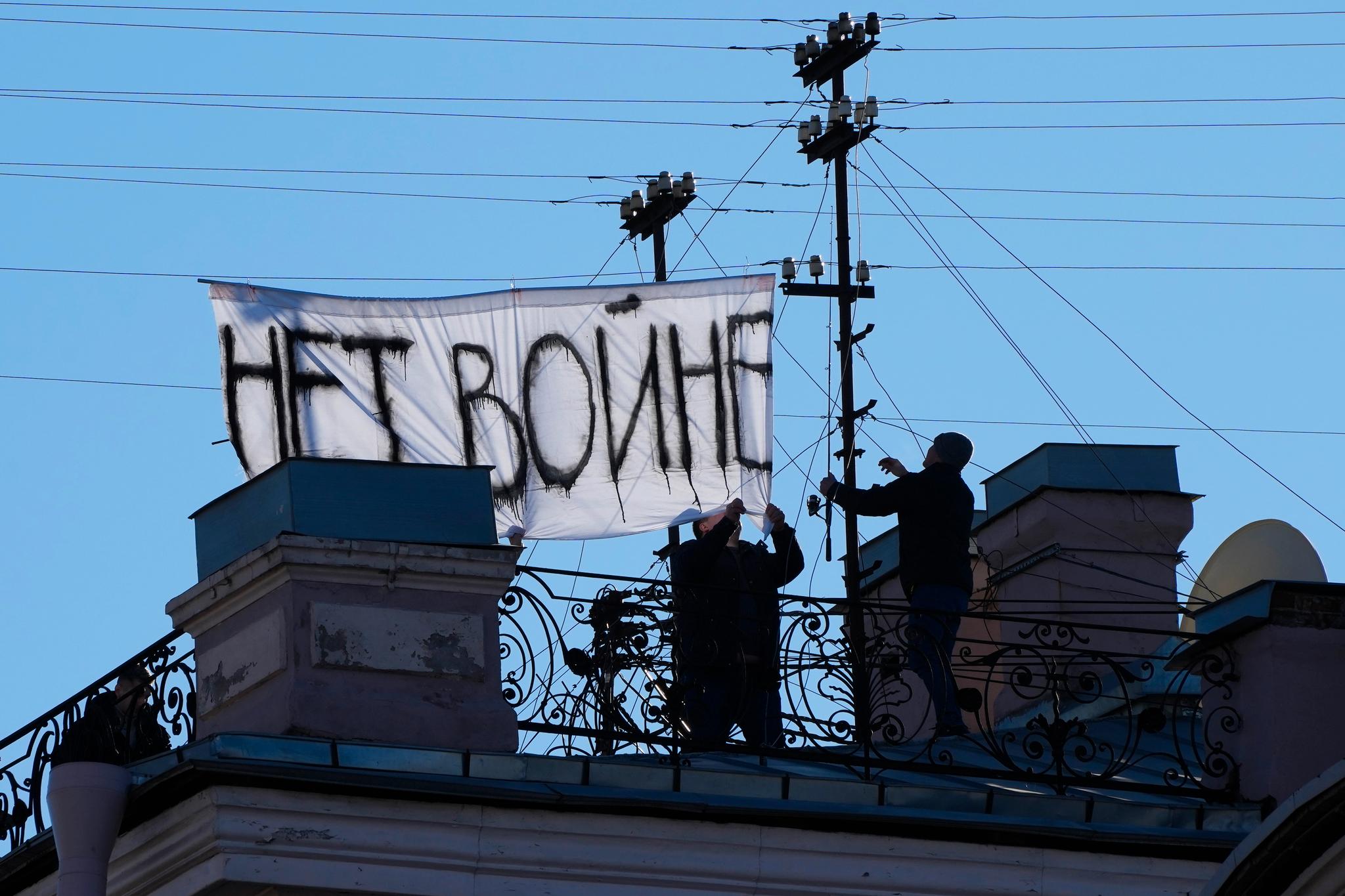 Et skilt med teksten «ingen krig» ble hengt opp i sentrum av den russiske byen. St. Petersburg. På dette bildet fra 1. mars er det i ferd med å fjernes. 