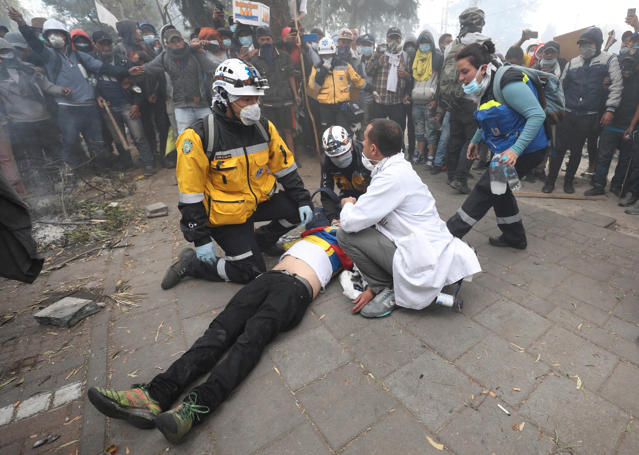 En såret demonstrant får legehjelp. Lørdag var det nye voldsomme sammenstøt mellom demonstranter og politi i Ecuadors hovedstad Quito. 
