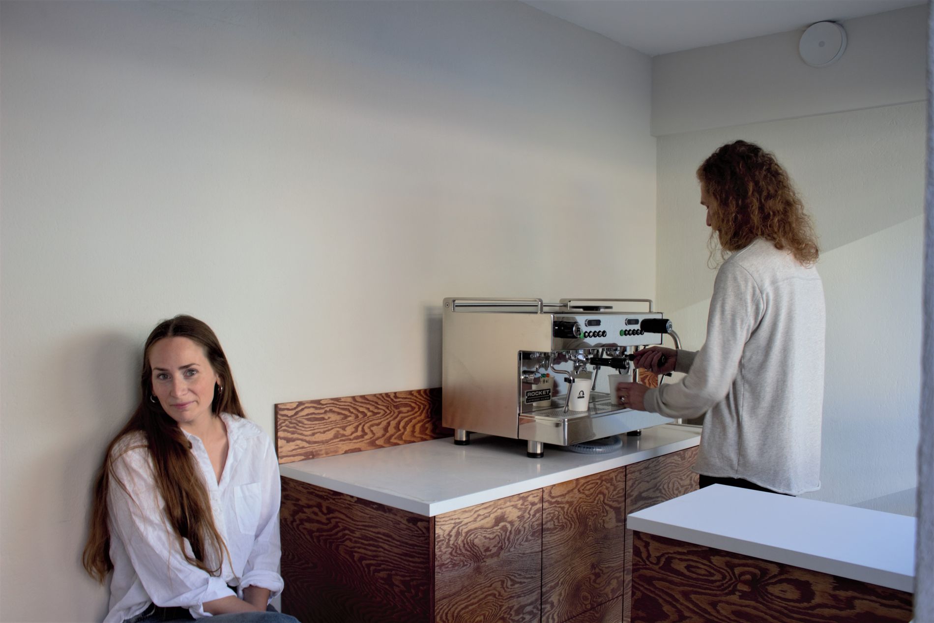 På benken til venstre kan kunder slå av en prat mens kaffen forberedes. 